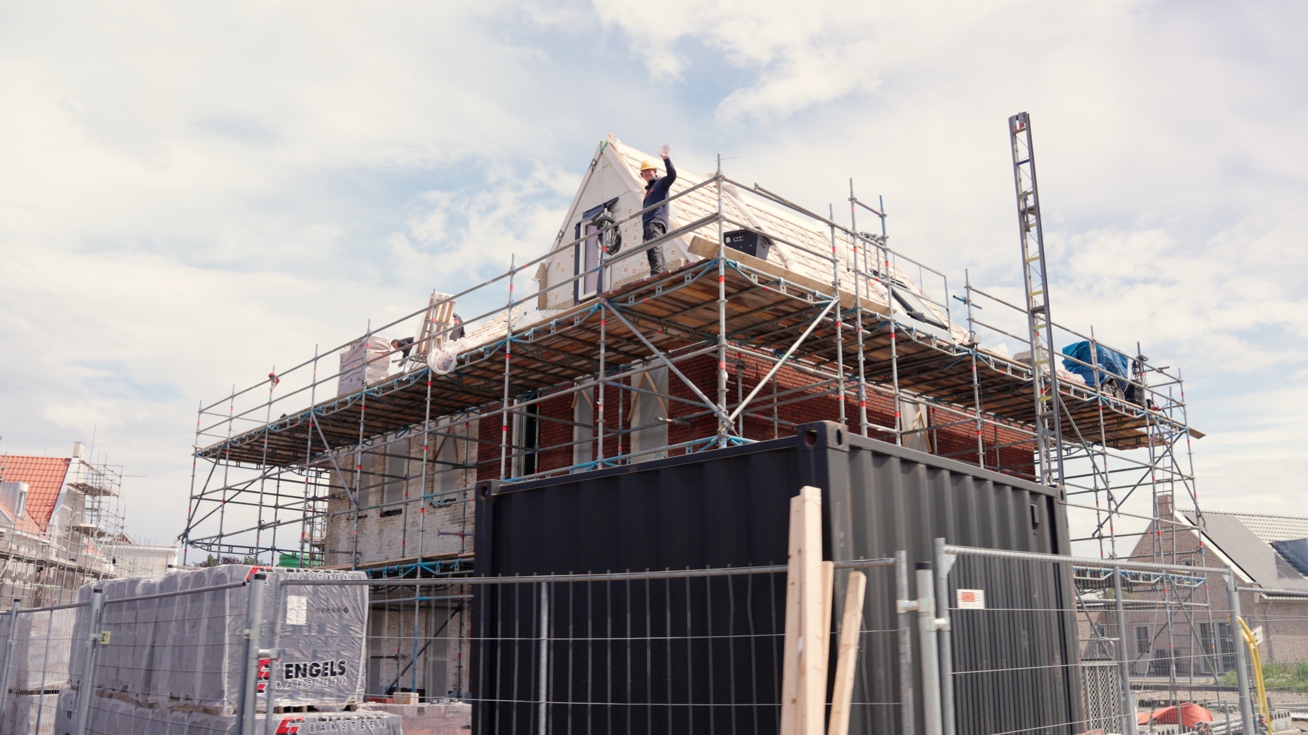 Workers on scaffolding finishing the roofline of a house on a Dutch construction site